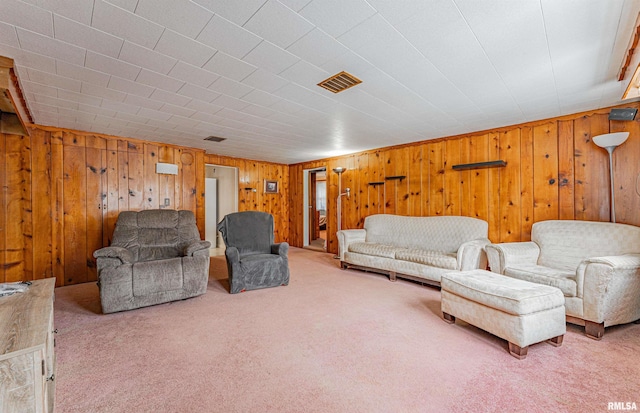 carpeted living room featuring wood walls