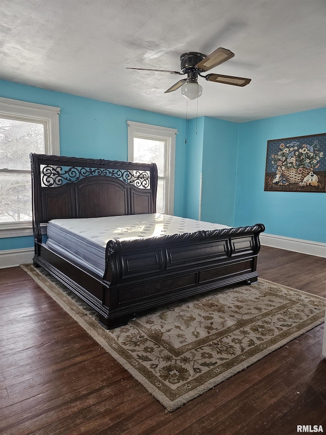 bedroom with dark hardwood / wood-style flooring and ceiling fan