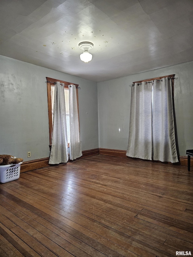 empty room with dark hardwood / wood-style flooring