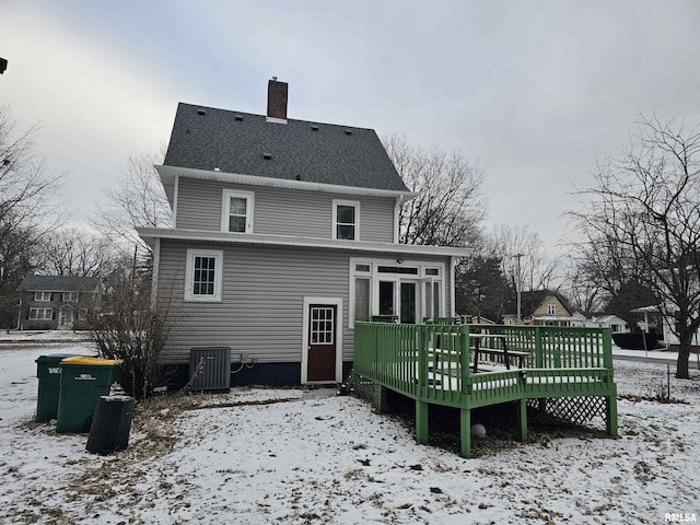 snow covered back of property featuring a deck and central air condition unit