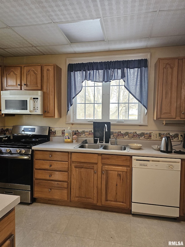 kitchen featuring sink, white appliances, and light tile patterned floors