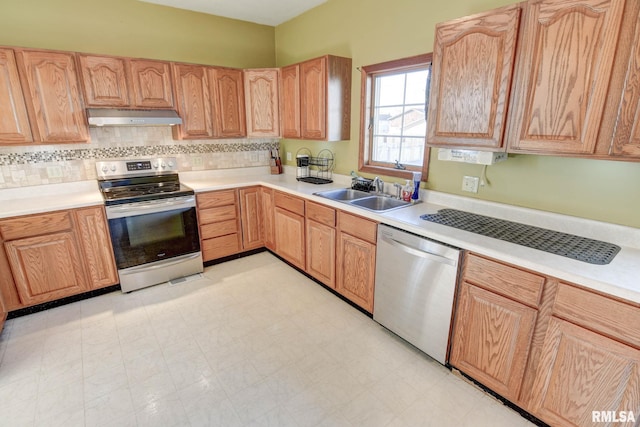 kitchen with ventilation hood, stainless steel appliances, a sink, and light countertops