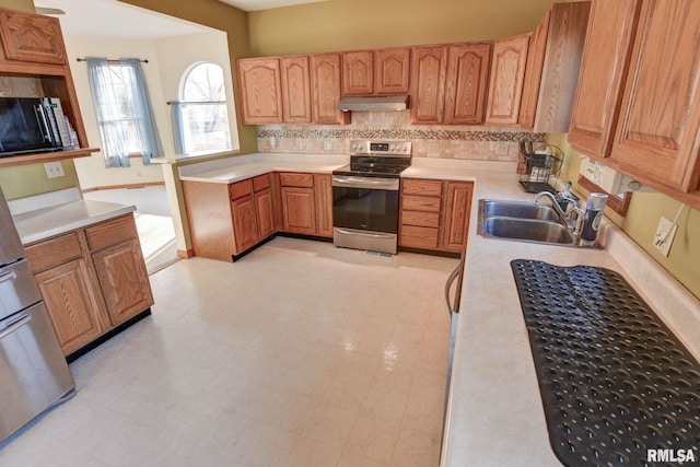 kitchen with light floors, light countertops, a sink, stainless steel range with electric stovetop, and under cabinet range hood