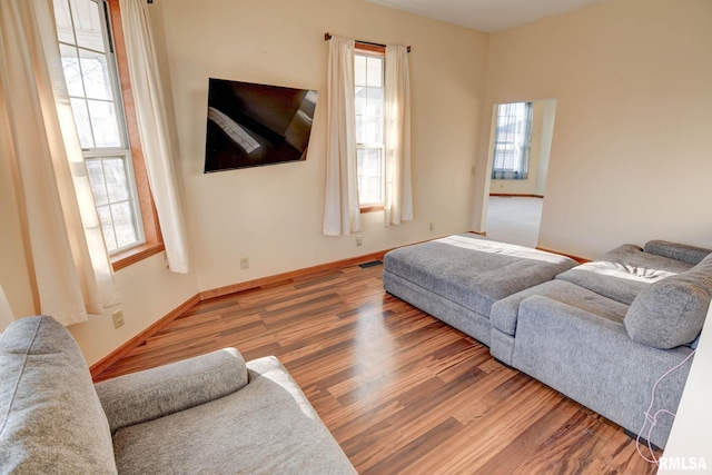 living area with visible vents, baseboards, and wood finished floors