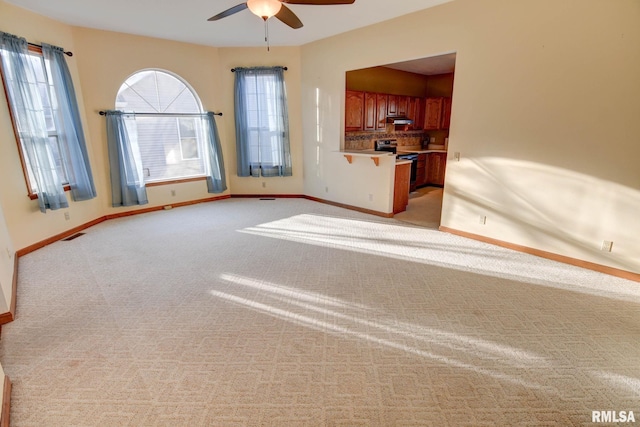 interior space with light carpet, ceiling fan, visible vents, and baseboards