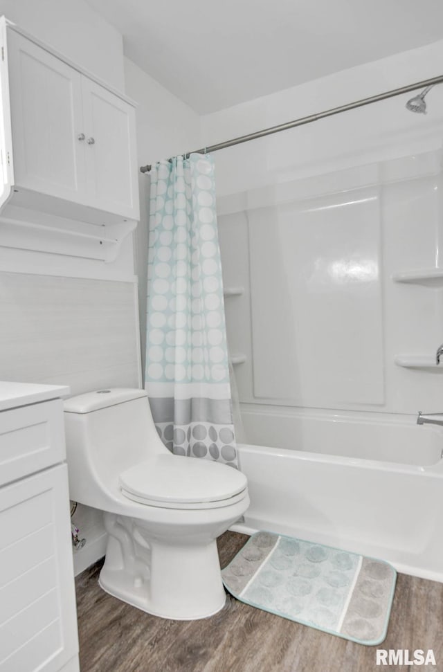 full bath featuring vanity, toilet, wood finished floors, and shower / tub combo