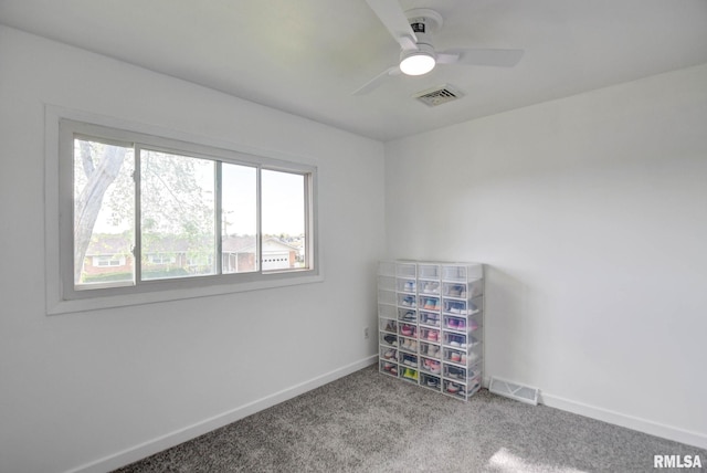 carpeted spare room featuring visible vents, a ceiling fan, and baseboards