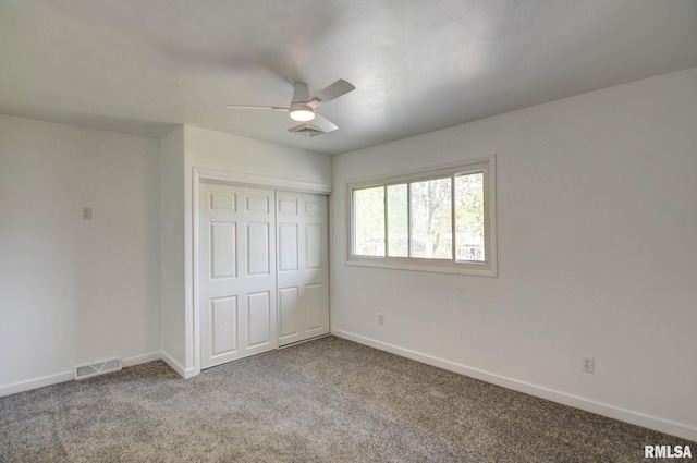 unfurnished bedroom featuring baseboards, carpet, a closet, and visible vents