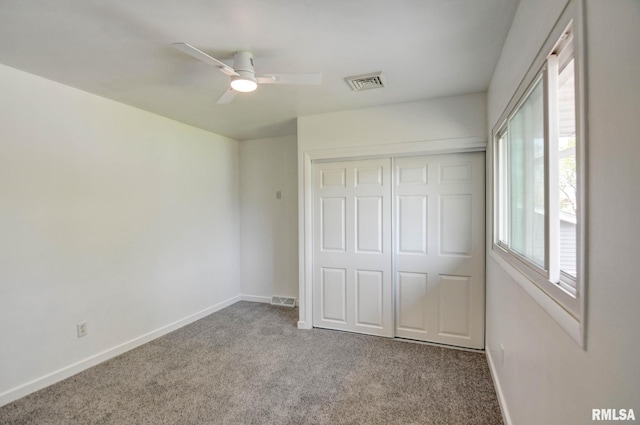 unfurnished bedroom with carpet floors, baseboards, and visible vents