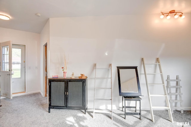 carpeted living area with baseboards