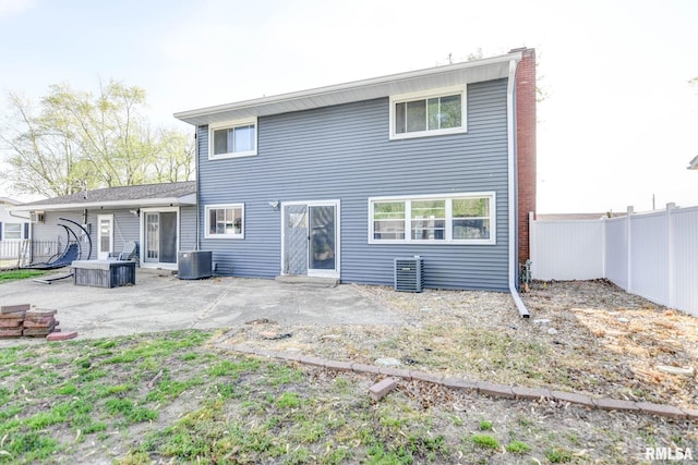 rear view of property featuring a patio, central AC unit, a fenced backyard, and a chimney