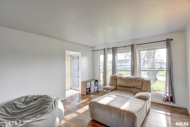living area featuring a healthy amount of sunlight, baseboards, and wood finished floors