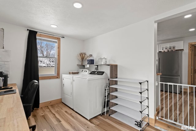 washroom featuring independent washer and dryer, a textured ceiling, and light hardwood / wood-style floors