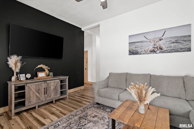 living room with ceiling fan and light hardwood / wood-style floors