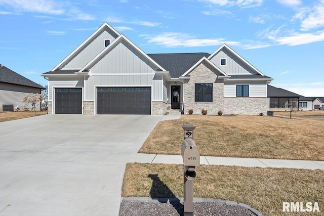 view of front of property with a garage, concrete driveway, stone siding, a front lawn, and board and batten siding