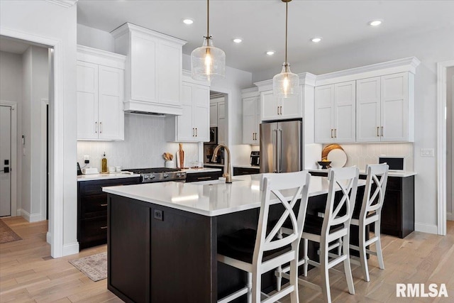 kitchen with high end fridge, light countertops, white cabinets, and recessed lighting