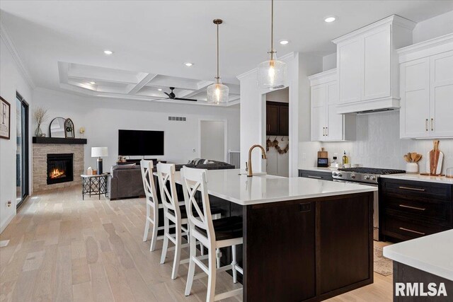 kitchen with light countertops, recessed lighting, coffered ceiling, and stainless steel gas stove