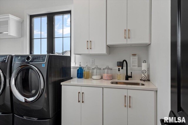laundry area featuring cabinet space, a sink, and washing machine and clothes dryer