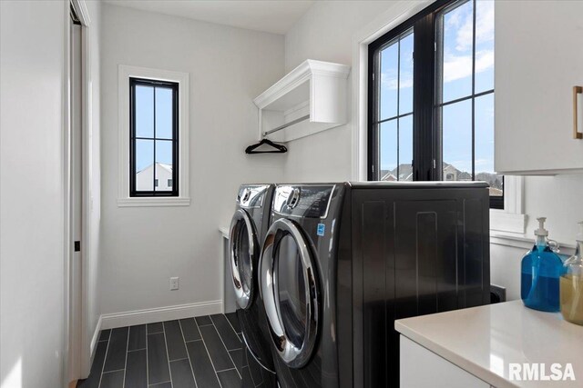 washroom with separate washer and dryer, baseboards, and cabinet space