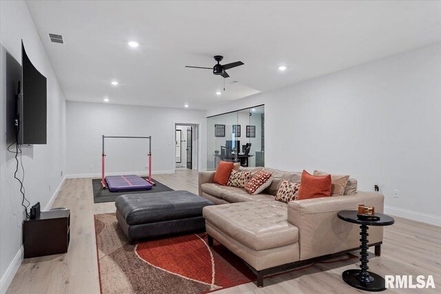 living room featuring a ceiling fan, baseboards, recessed lighting, and light wood-type flooring