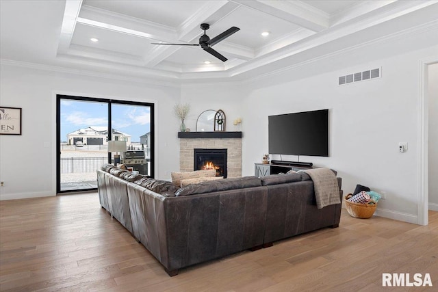 living room featuring a ceiling fan, visible vents, light wood-type flooring, and a fireplace