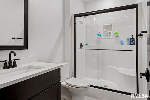 bathroom featuring vanity, a stall shower, and toilet