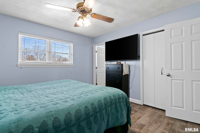 bedroom featuring a ceiling fan, wood finished floors, and a closet