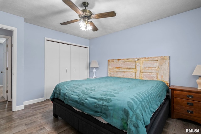 bedroom with baseboards, a closet, ceiling fan, and wood finished floors