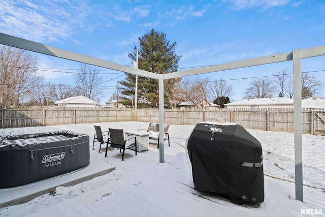 yard covered in snow featuring a fenced backyard and a hot tub