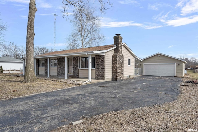 ranch-style house featuring a porch, a chimney, an outdoor structure, and a detached garage