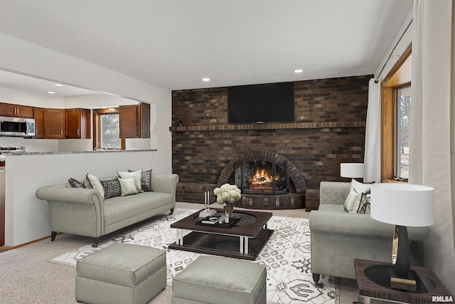 living room with recessed lighting, a fireplace, a wealth of natural light, and light colored carpet