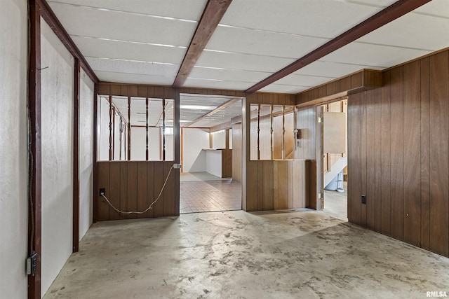 interior space with wooden walls and unfinished concrete flooring