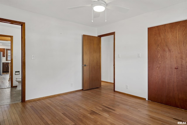 unfurnished bedroom featuring ceiling fan, light wood finished floors, a closet, and baseboards