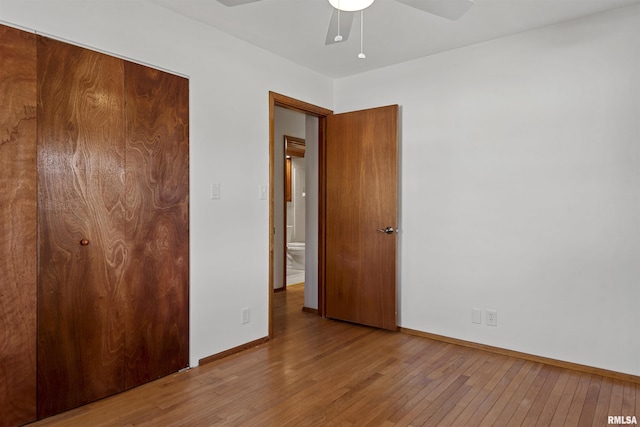 unfurnished bedroom with a closet, ceiling fan, baseboards, and wood finished floors