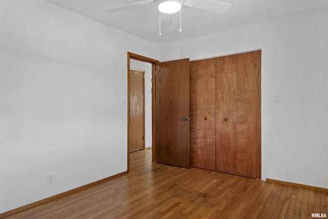 unfurnished bedroom with a ceiling fan, a closet, baseboards, and wood finished floors