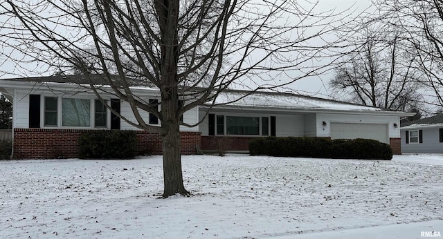 single story home featuring a garage and brick siding