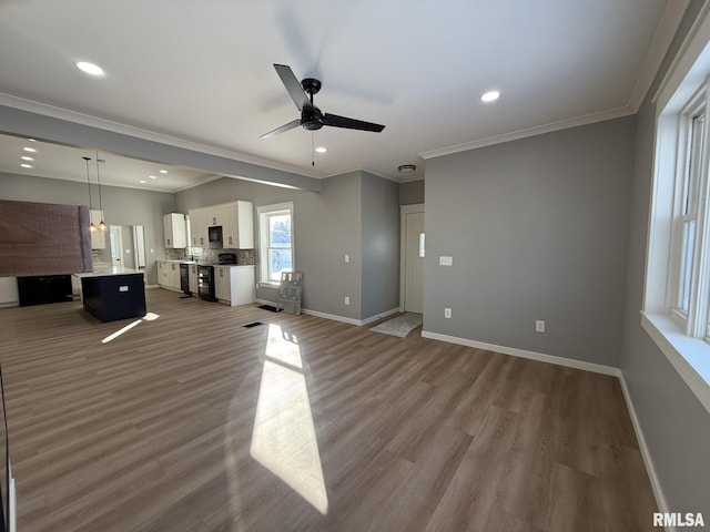 unfurnished living room with crown molding, recessed lighting, a ceiling fan, and wood finished floors