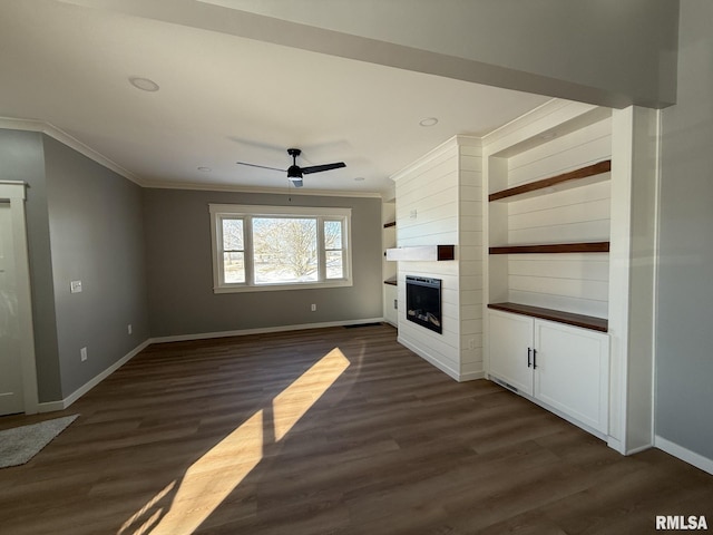 unfurnished living room with ornamental molding, a ceiling fan, a large fireplace, and baseboards