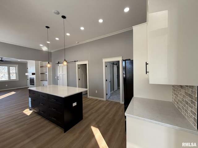 kitchen with baseboards, dark cabinets, crown molding, and dark wood-type flooring