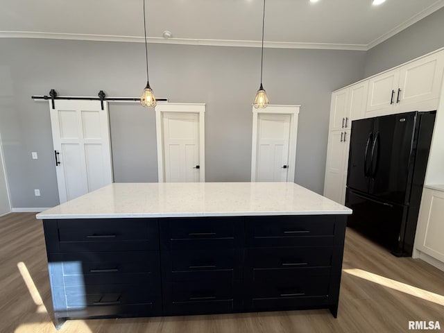 kitchen featuring crown molding, freestanding refrigerator, a center island, light wood finished floors, and dark cabinetry