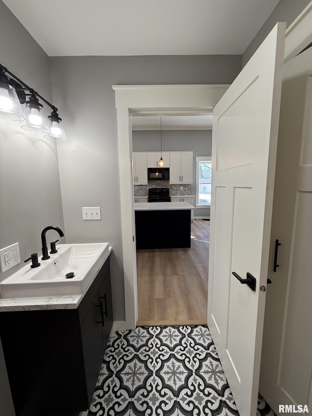 bathroom featuring tasteful backsplash, wood finished floors, and vanity
