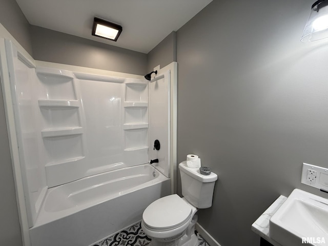 bathroom featuring a sink, baseboards, toilet, tile patterned floors, and shower / washtub combination