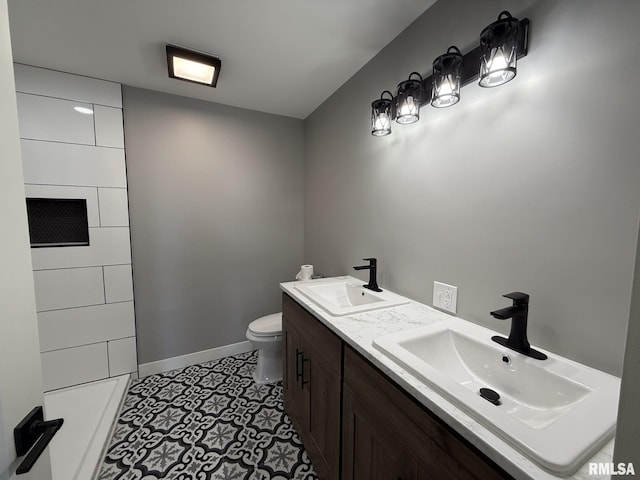 full bathroom with baseboards, toilet, double vanity, and a sink