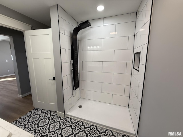 full bathroom featuring a shower stall, baseboards, and wood finished floors