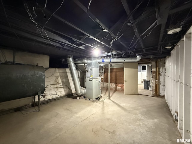 unfinished basement featuring heating unit and heating fuel