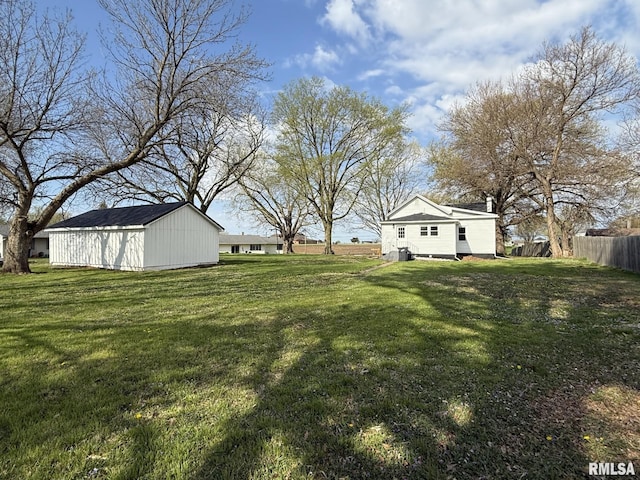 view of yard featuring fence and an outbuilding