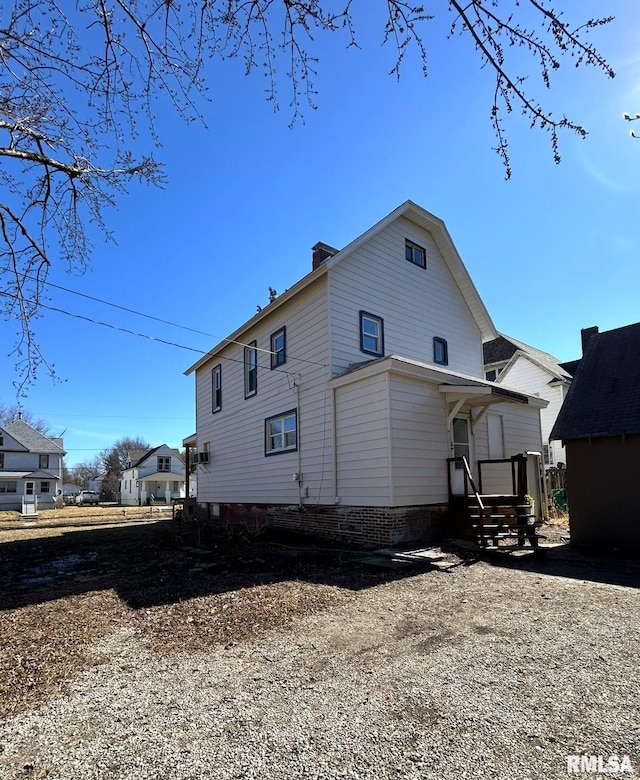 back of house with a chimney