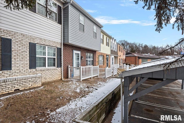 snow covered property featuring brick siding