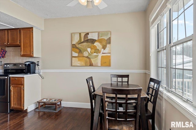 dining space featuring dark wood-type flooring, ceiling fan, a textured ceiling, and baseboards