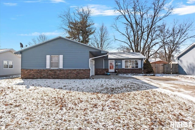 view of front of house featuring fence and brick siding